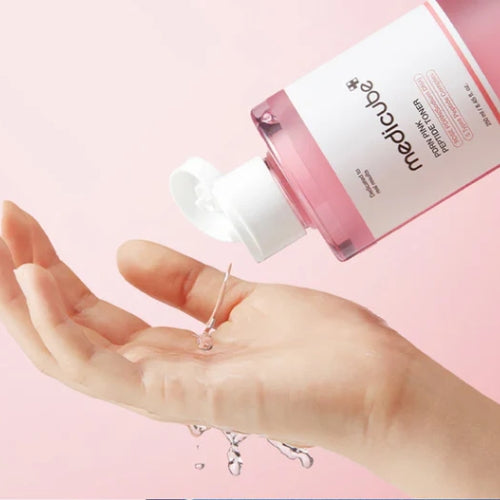 Medicube PDRN Pink Cica Soothing Toner helles i hånden for påføring på huden
