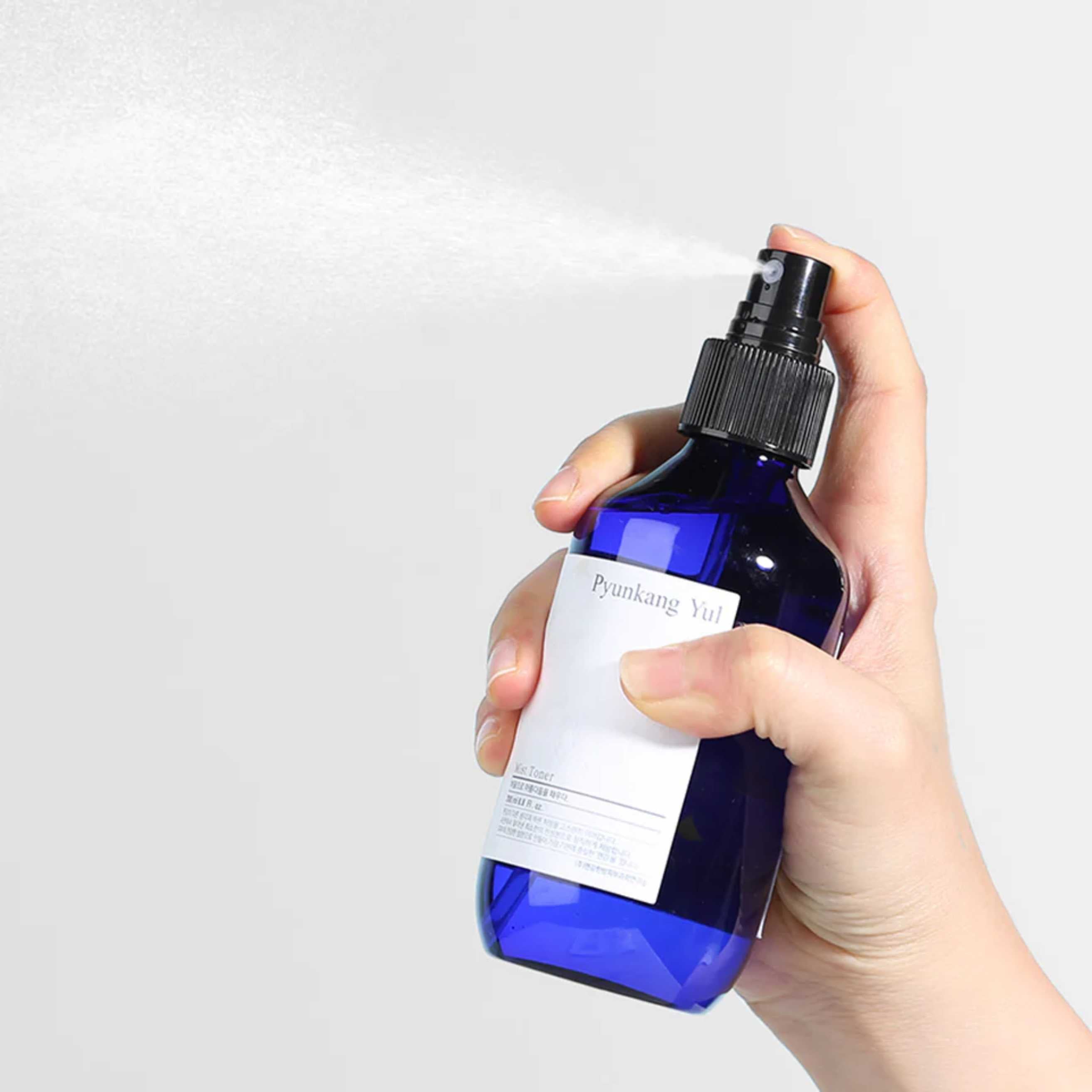 Pyunkang Yul Mist Toner sprayes på hånd fra blå flaske